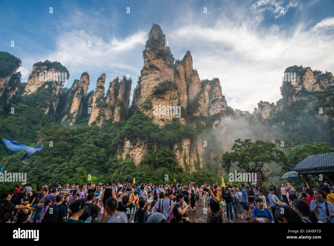 Zhangjiajie, China - August 2019 : Massive tourist crowds on the square at the bottom of Bailong Elevator lift with the Soldiers Gathering peaks behin Stock Photo