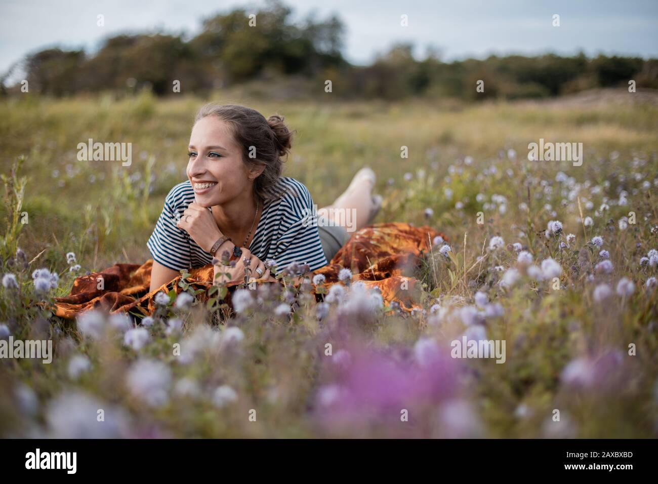 Woman lying down in a field of flowers during daytime Stock Photo - Alamy