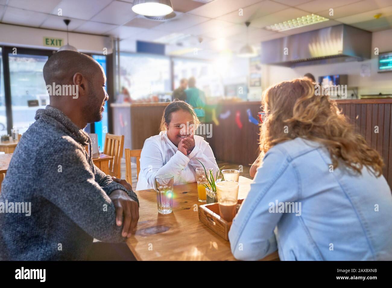 Happy young woman with Down Syndrome in cafe with parents Stock Photo