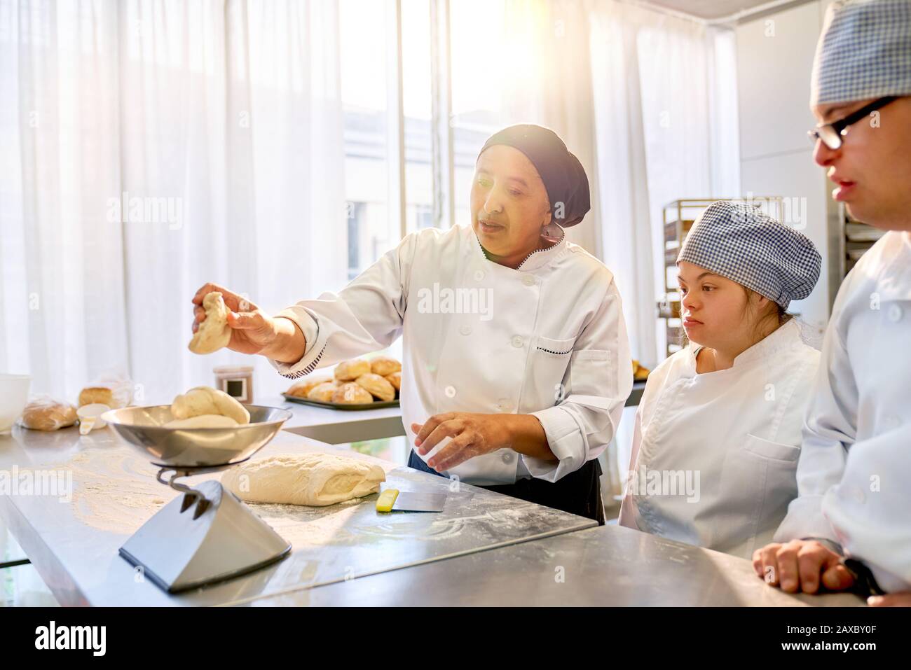 Chef teaching students with Down Syndrome how to bake Stock Photo