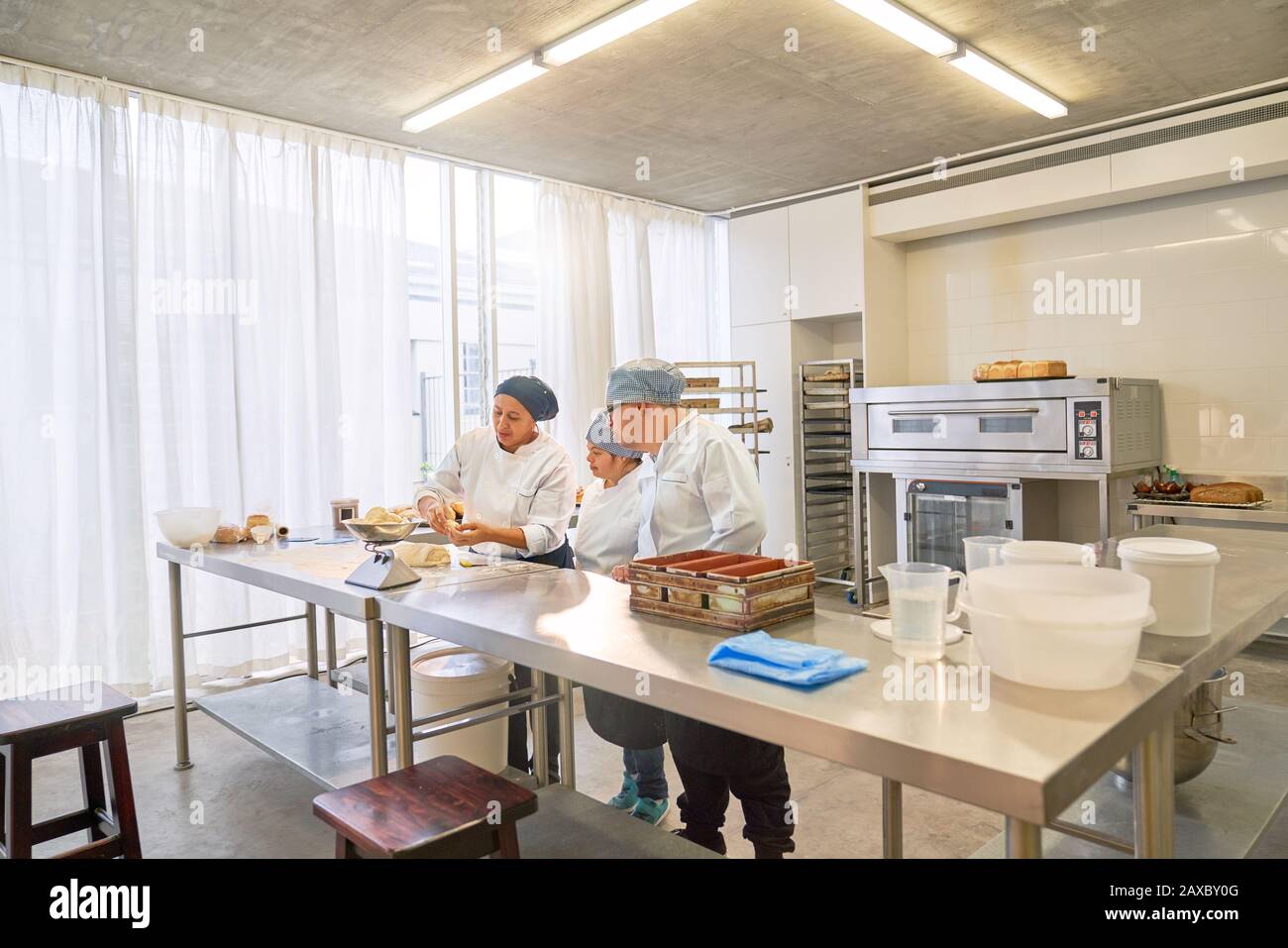 Chef and students with Down Syndrome baking in restaurant kitchen Stock Photo