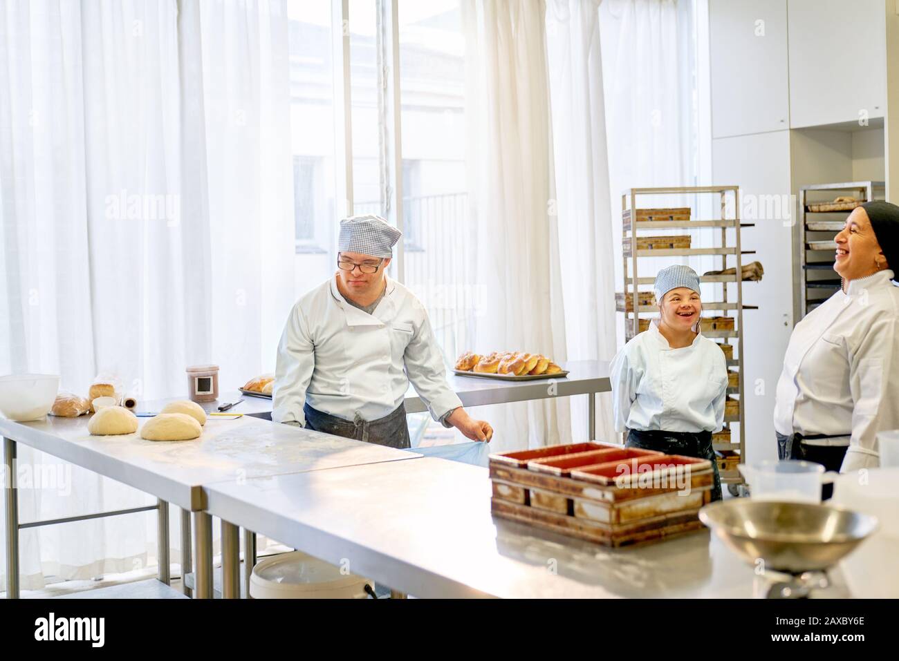 Happy chef and students with Down Syndrome baking in kitchen Stock Photo