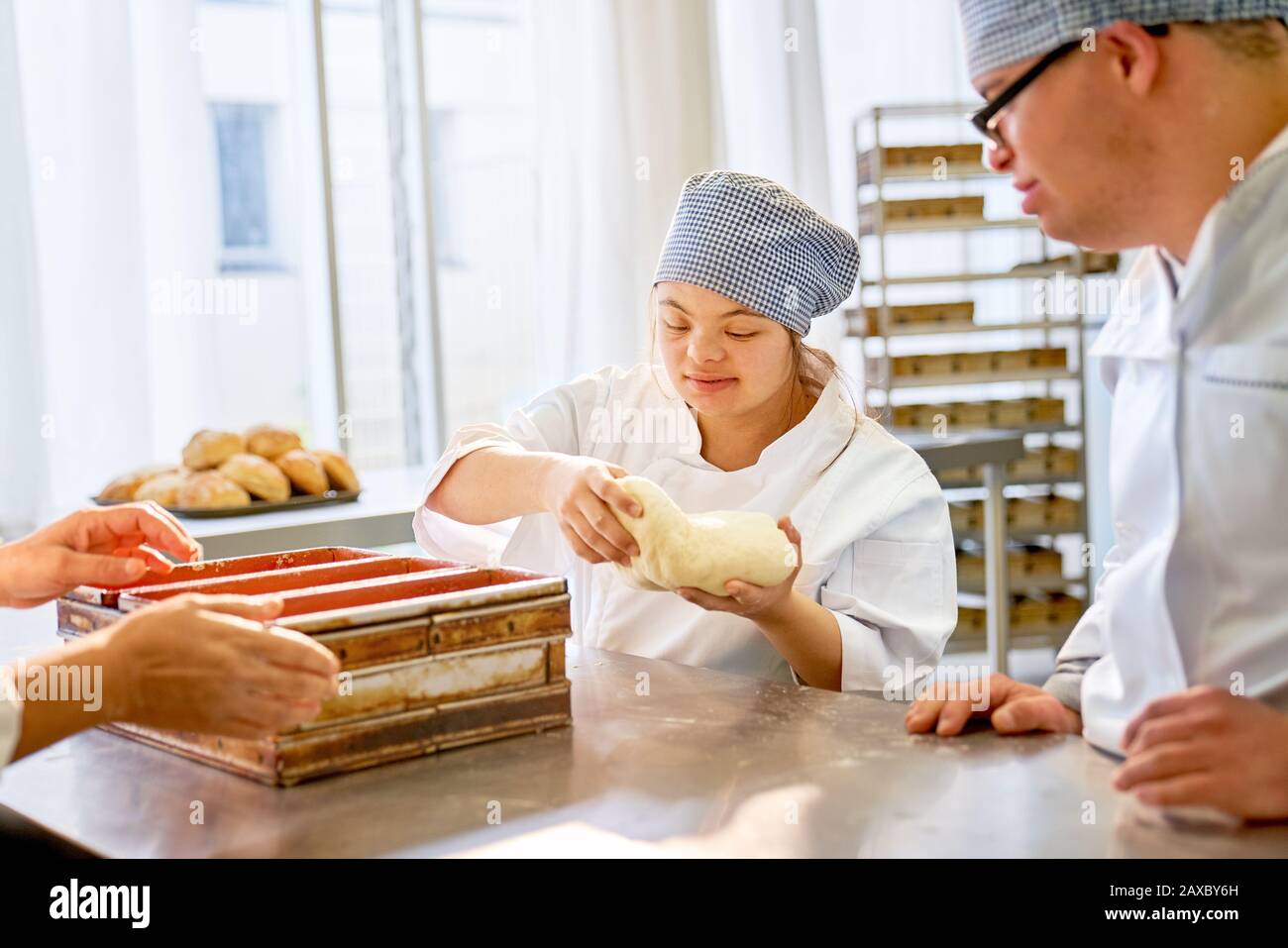 Young students with Down Syndrome baking bread in class Stock Photo