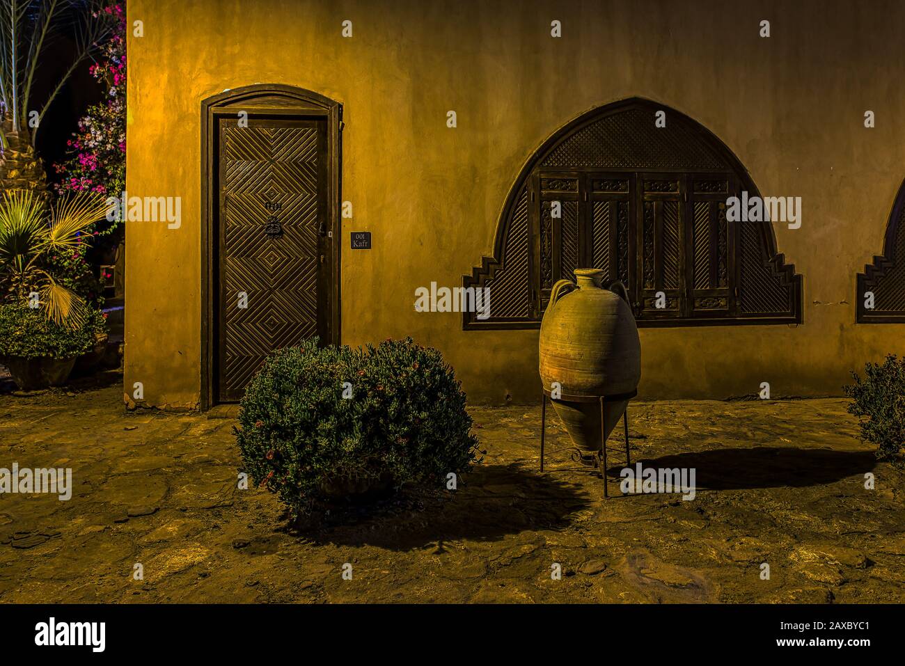 the exterior facade of an Egyptian villa with wooden door and shutters at night, el Gouna, Egypt, January 16, 2020 Stock Photo