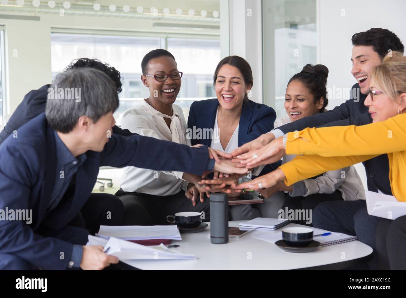 Business people joining hands in meeting Stock Photo
