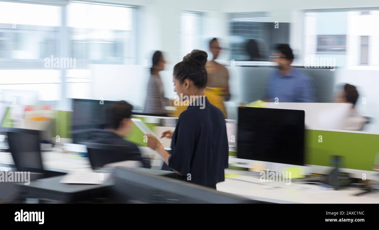 Businesswoman with digital tablet walking in office Stock Photo