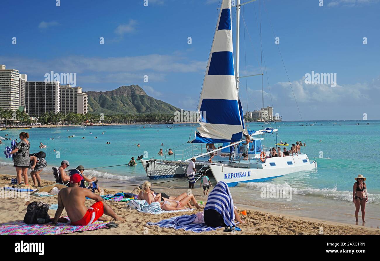 Catamaran cruise boat picking up passengers on Waikiki Beach in Honolulu, Hawai'i. Stock Photo