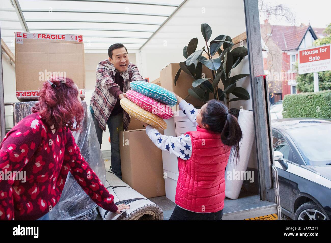 Friends moving, unloading moving van Stock Photo