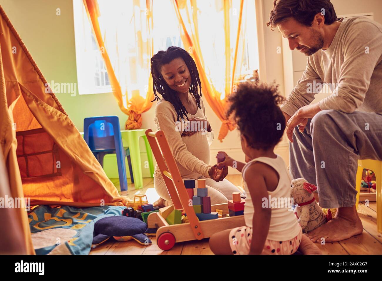 Pregnant young family playing with toys Stock Photo