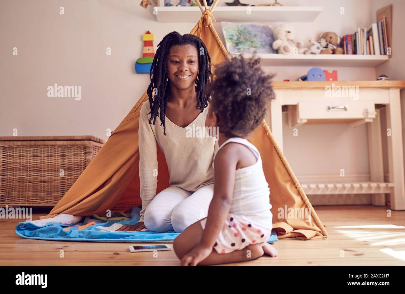 Mother and daughter playing on bedroom floor Stock Photo