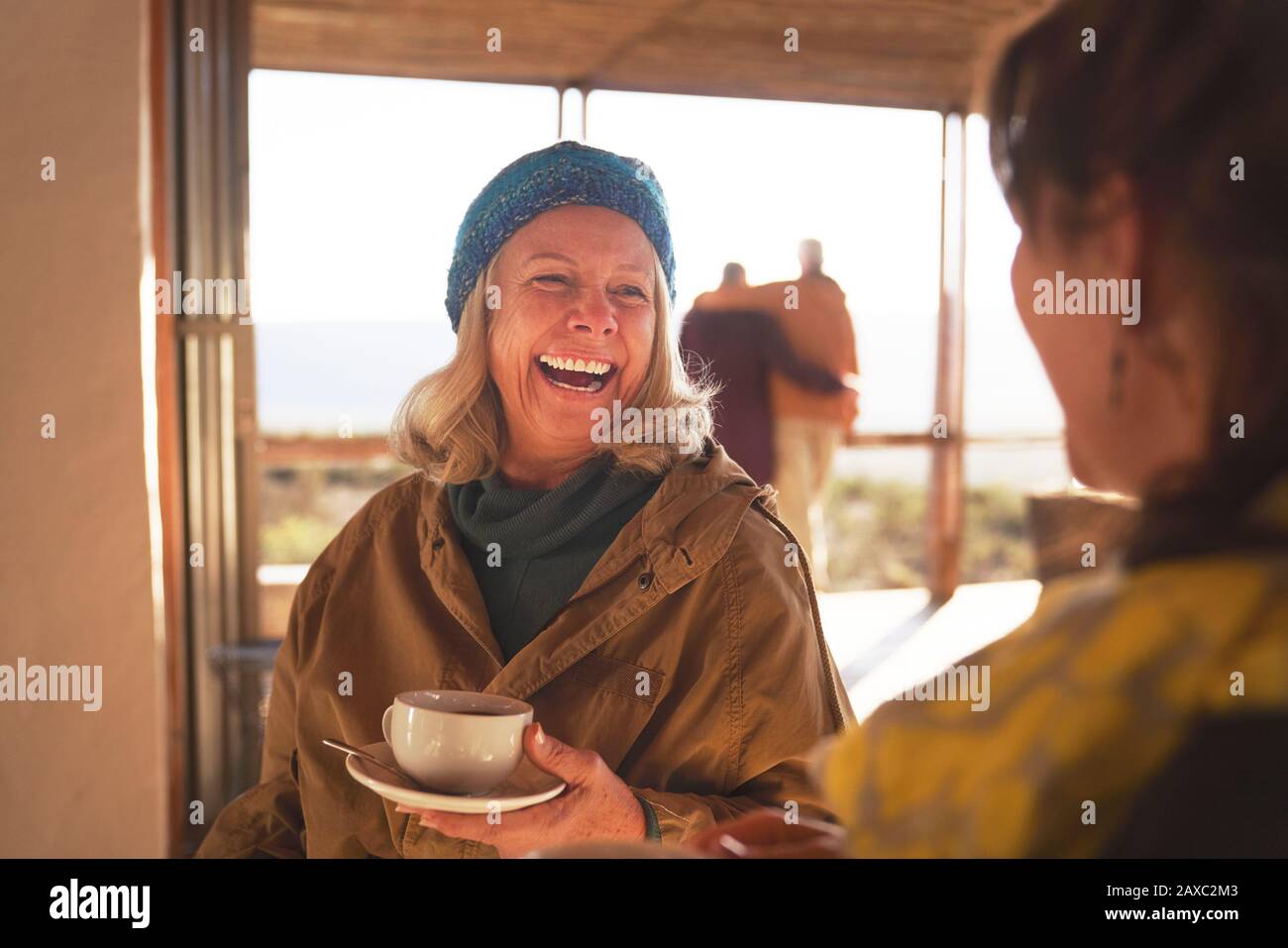 Happy senior women friends enjoying coffee and laughing Stock Photo