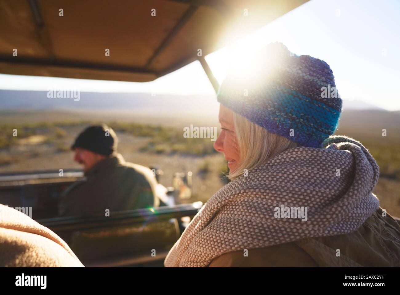 Happy senior woman riding in sunny safari off-road vehicle Stock Photo