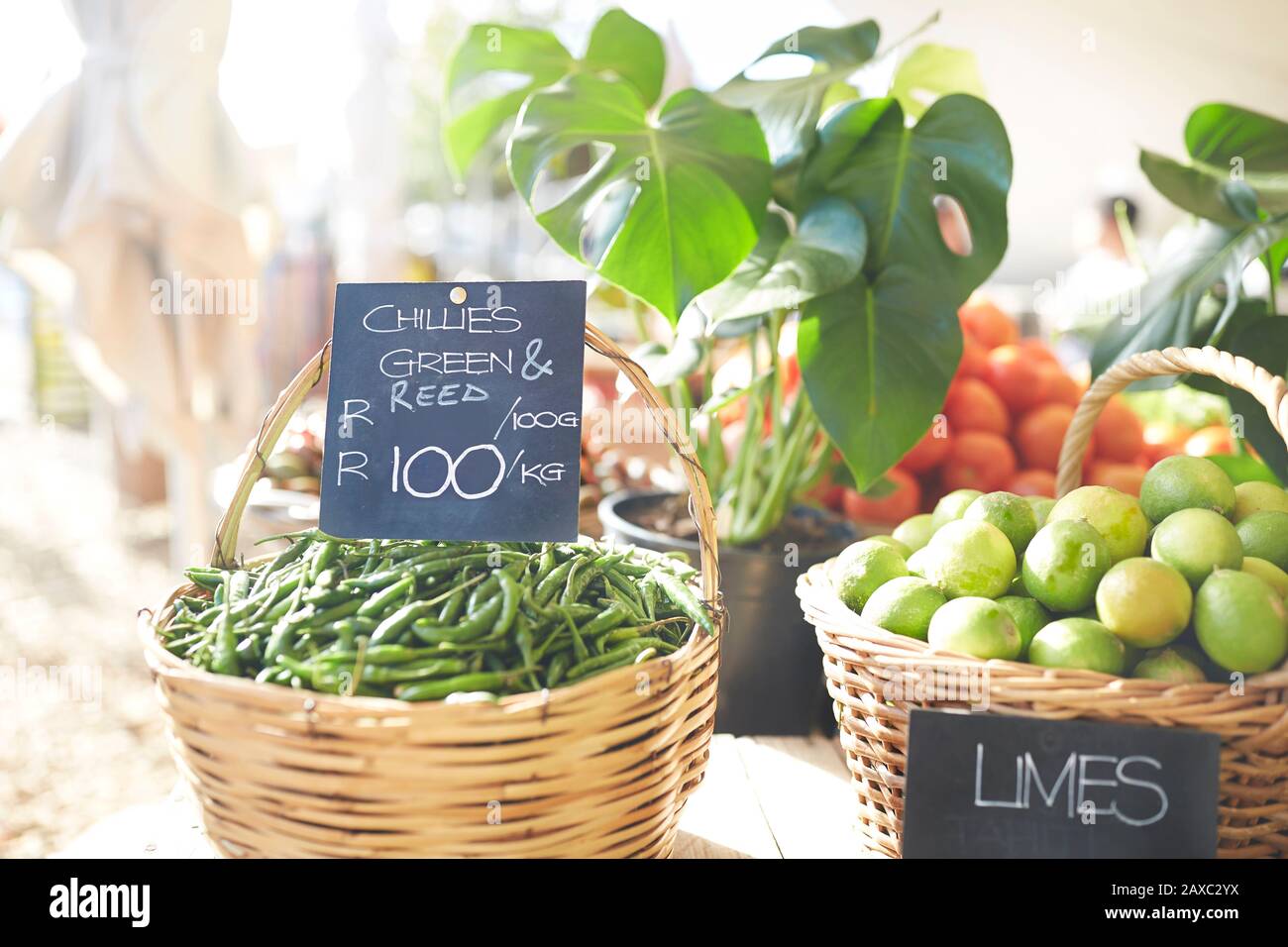 Baskets of fresh green chills and limes at farmer’s market Stock Photo