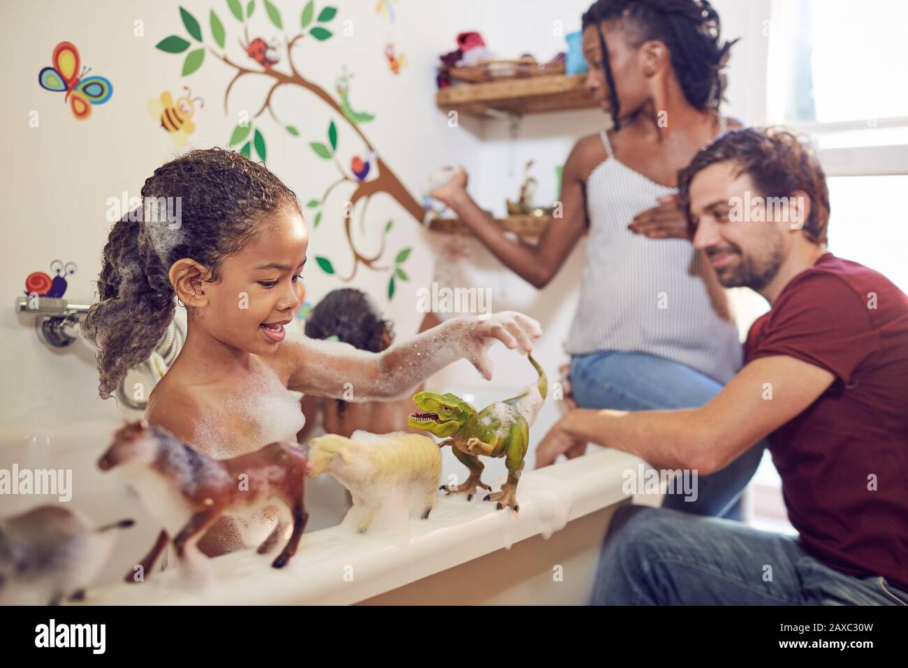 Pregnant parents giving daughters bubble bath Stock Photo Alamy