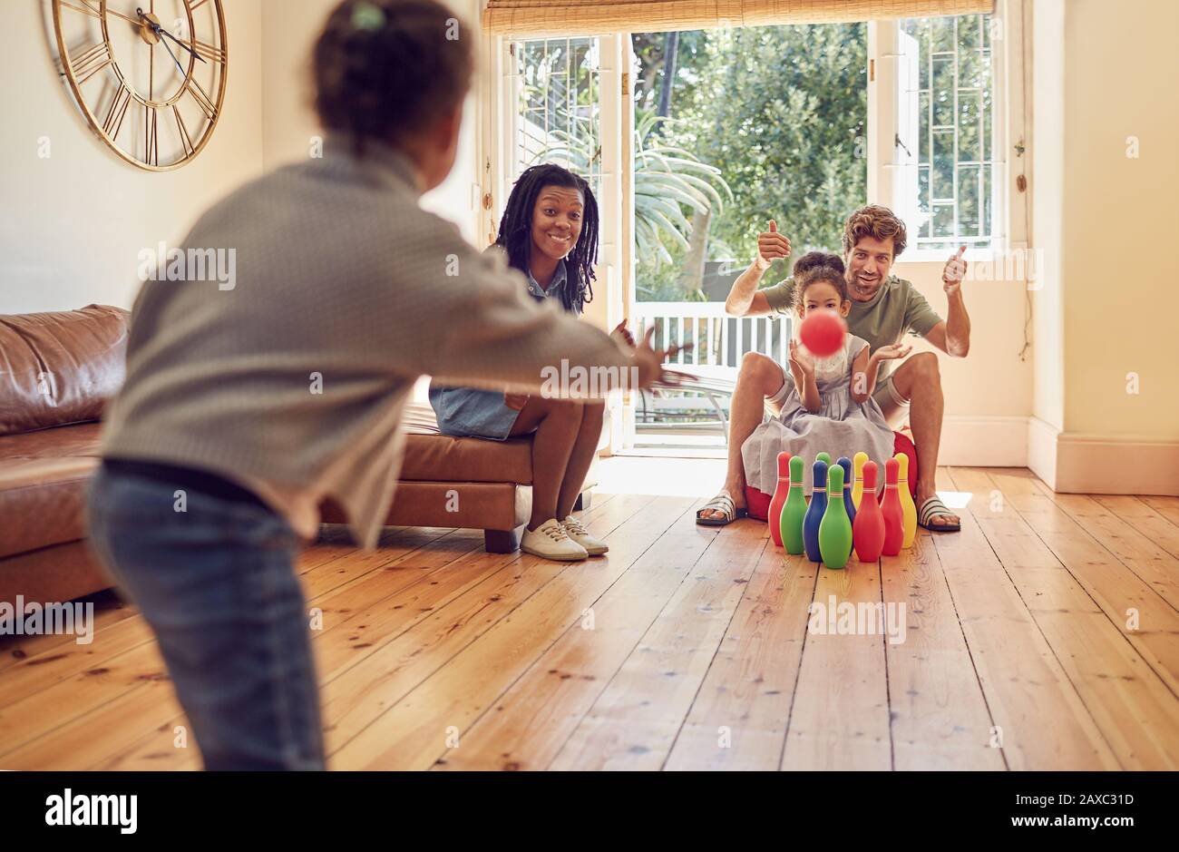 Young family playing bowling in living room Stock Photo