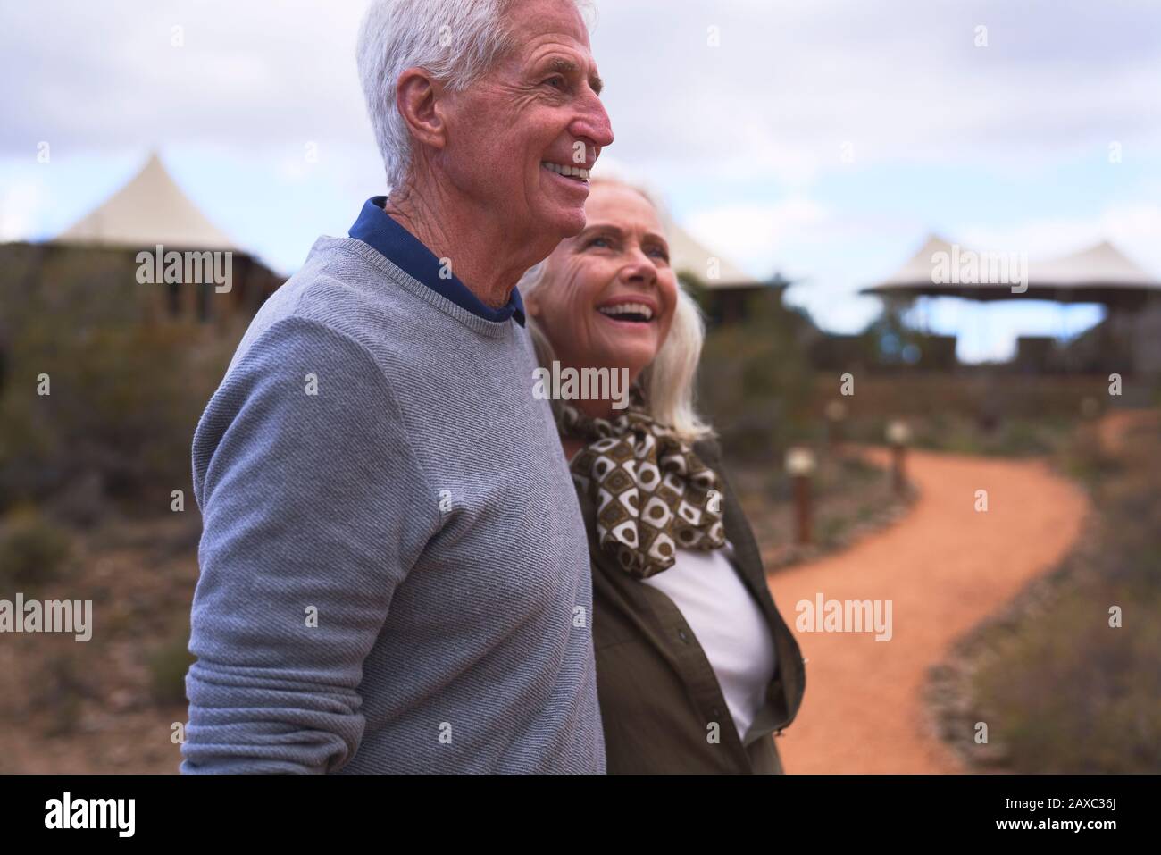 Happy senior couple on footpath outside safari lodge Stock Photo