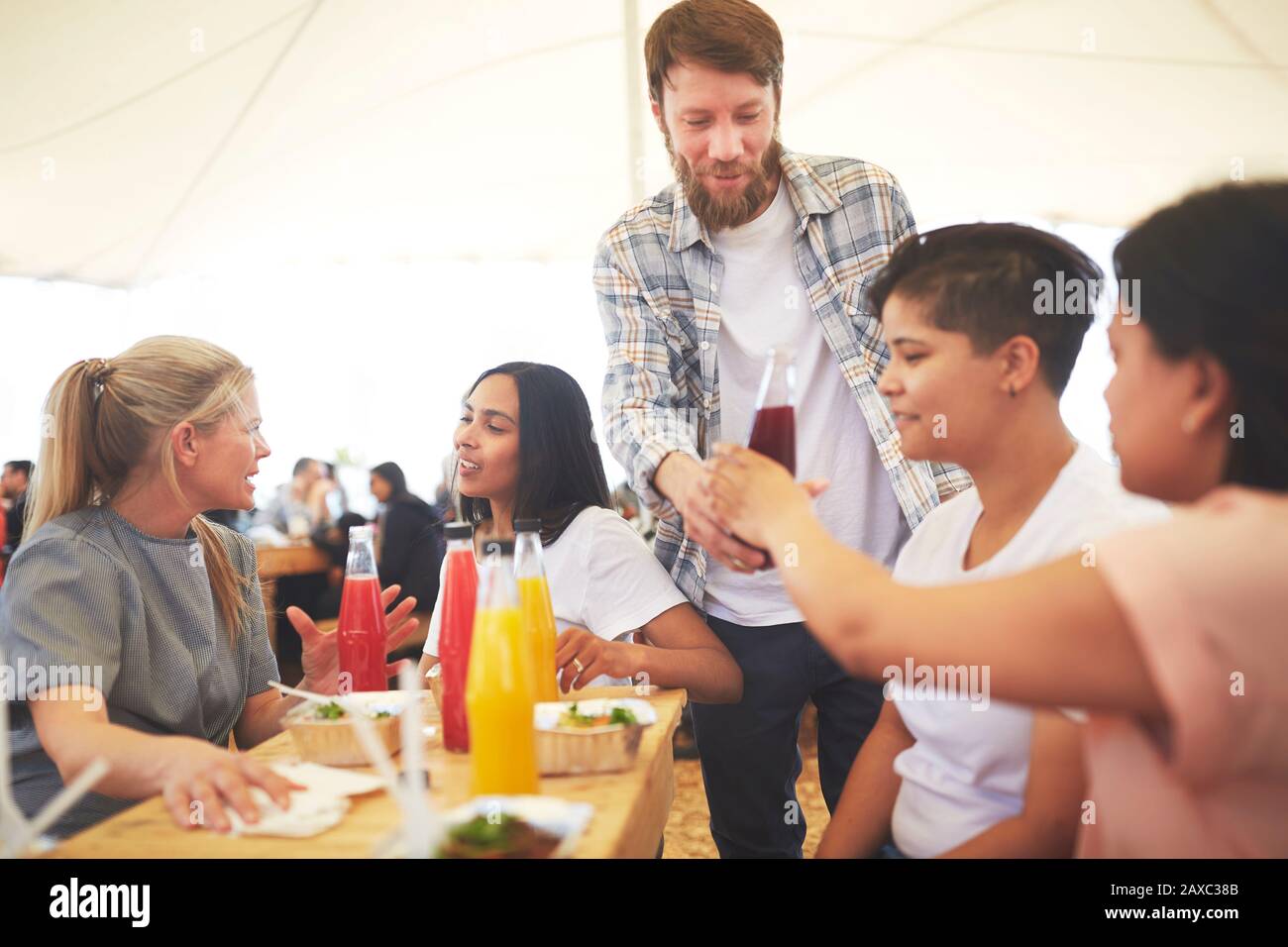 Man serving juice to friends at farmer’s market Stock Photo