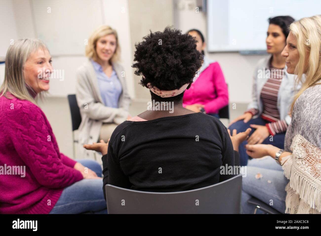 Women talking in support group meeting circle Stock Photo