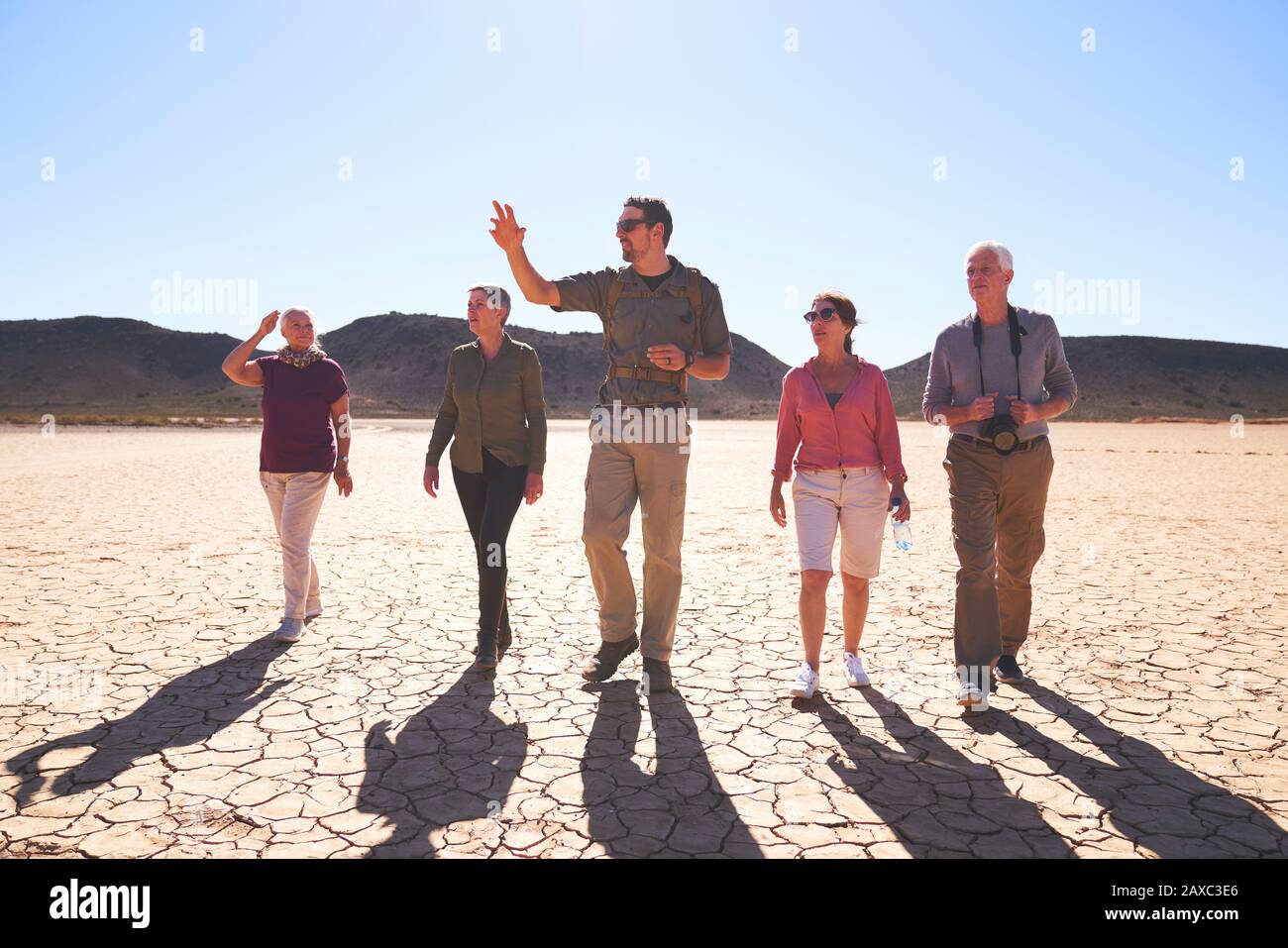 Safari tour guide leading group in sunny arid desert South Africa Stock Photo