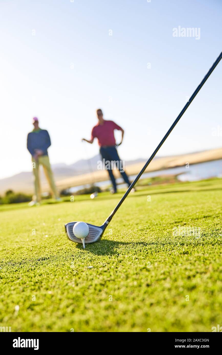 Golfer preparing to tee off on sunny golf course Stock Photo