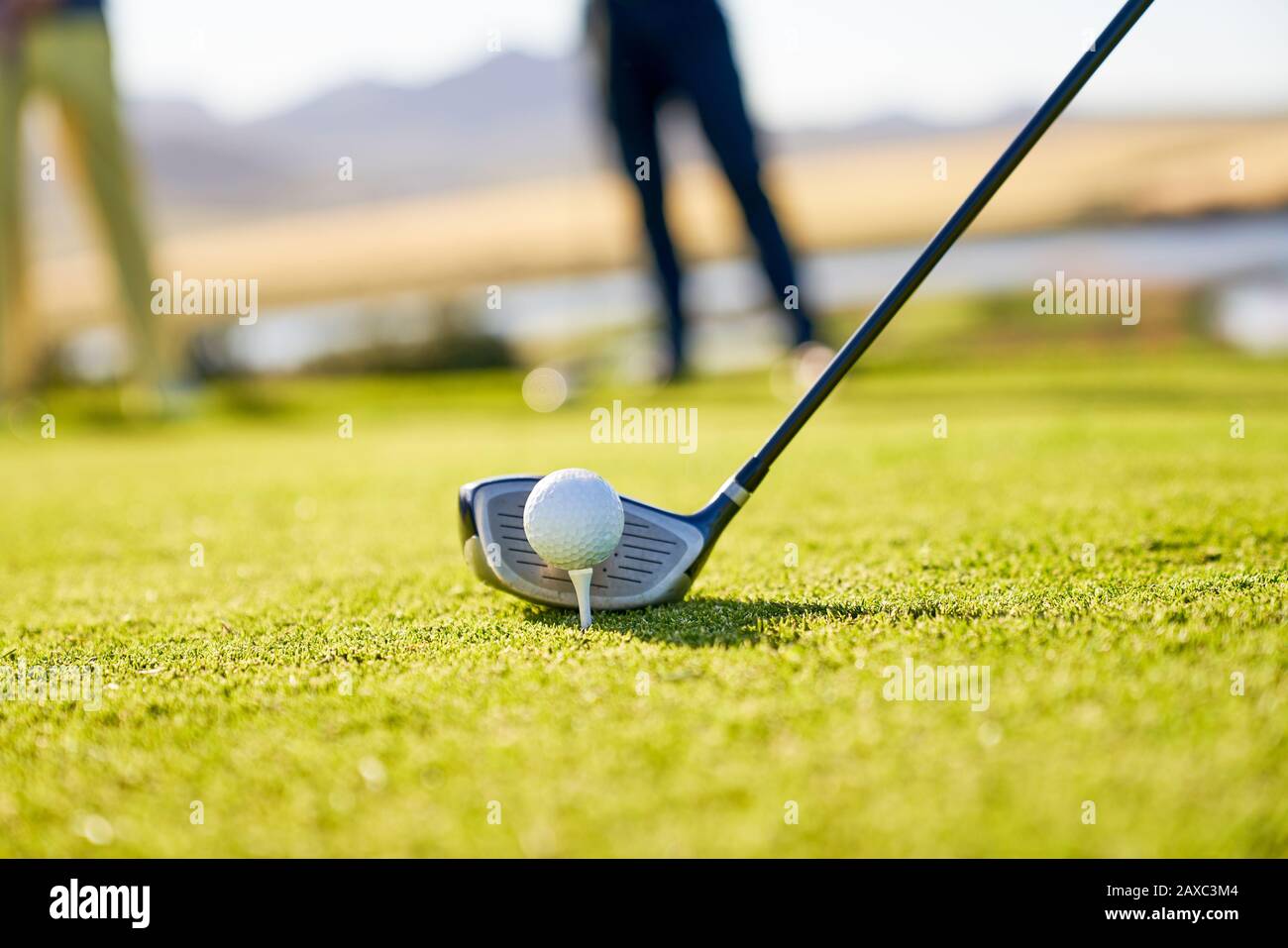 Close up golfer preparing to tee off at sunny tee box Stock Photo