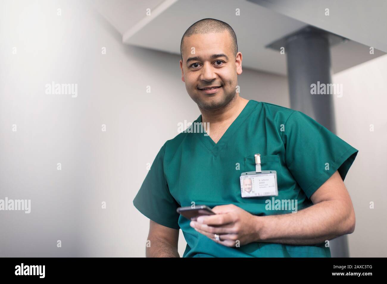 Portrait confident, smiling male surgeon using smart phone Stock Photo