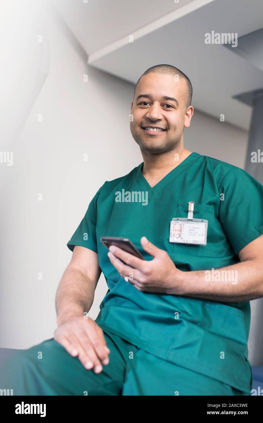 Portrait confident male surgeon using smart phone Stock Photo