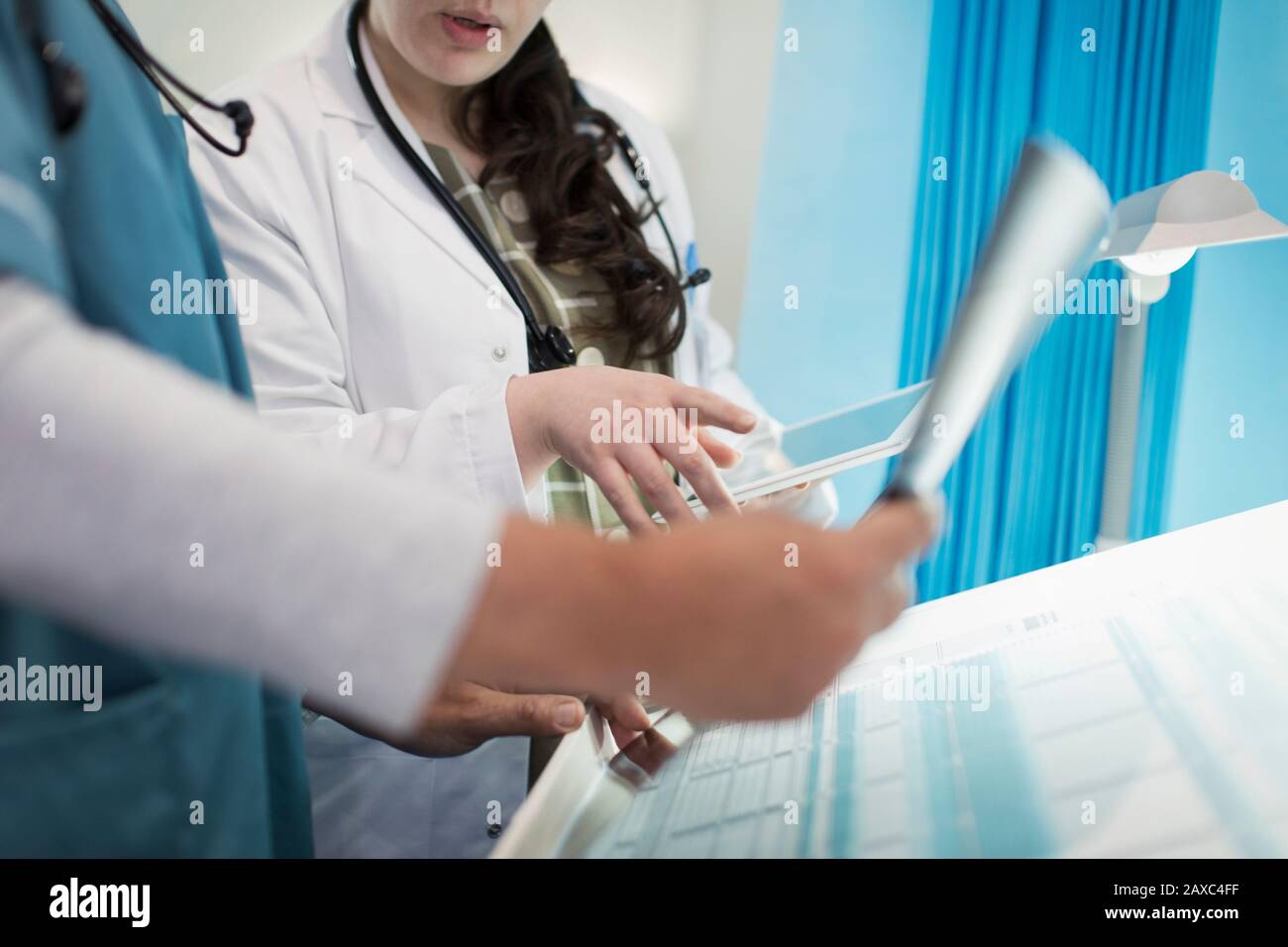 Doctors with digital tablet discussing x-ray in hospital room Stock Photo