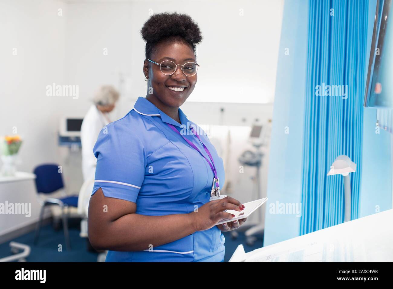 Portrait confident female nurse using digital tablet in hospital room Stock Photo