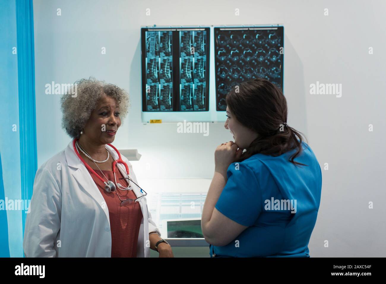 Female doctor and nurse discussing x-rays in in hospital Stock Photo