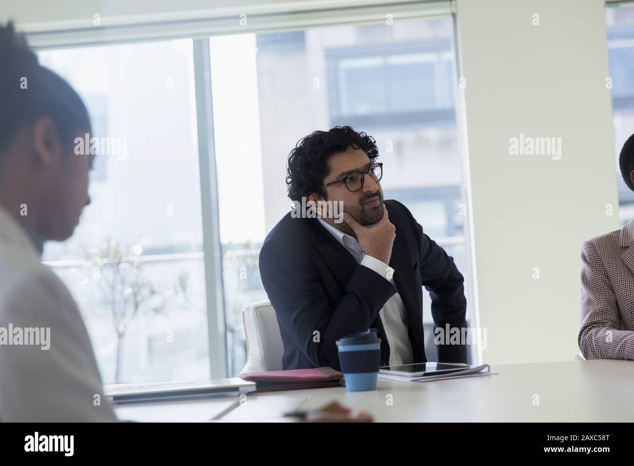 Thoughtful businessman listening in conference room meeting Stock Photo