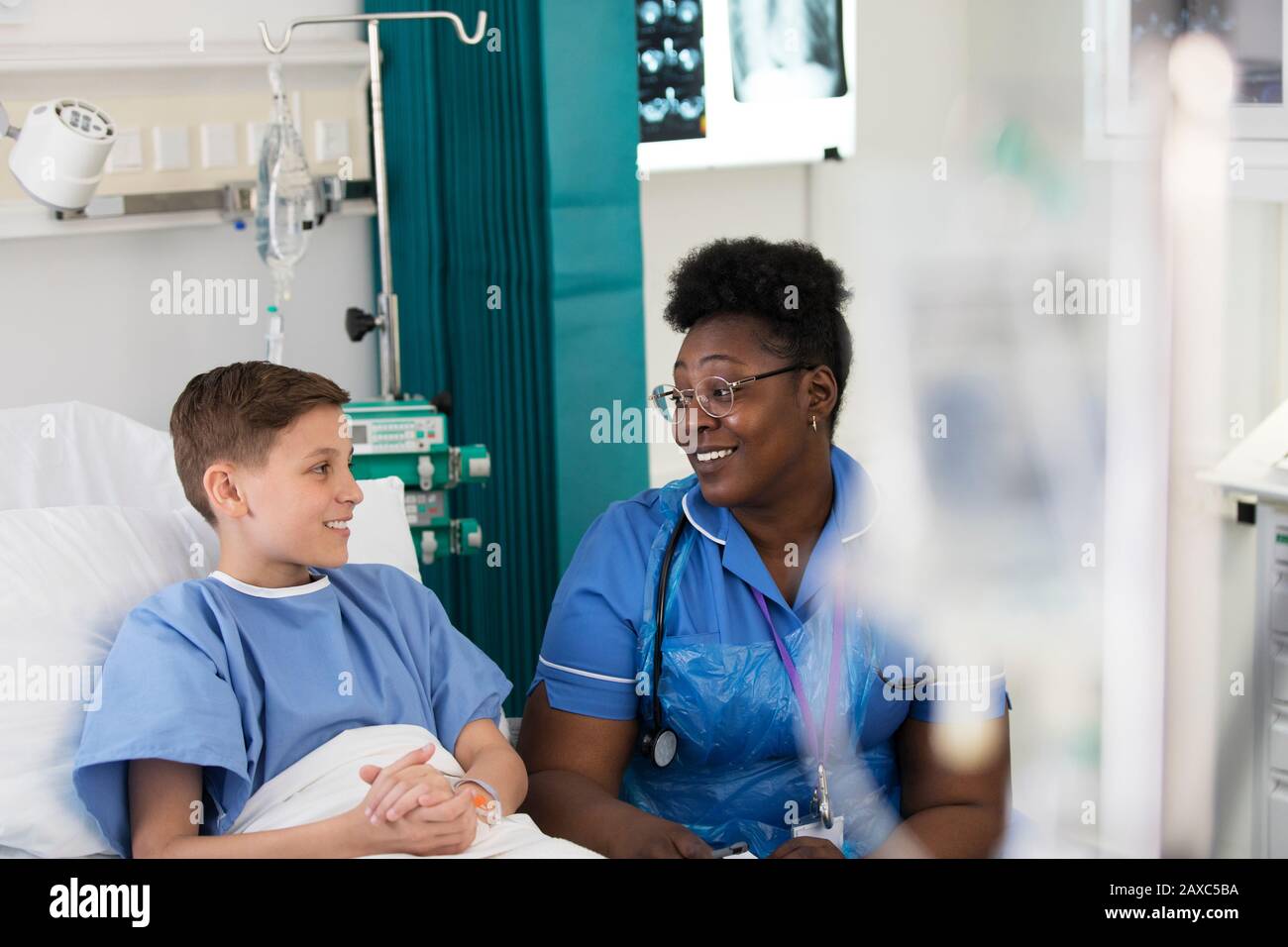 Female nurse talking with boy patient in hospital room Stock Photo - Alamy