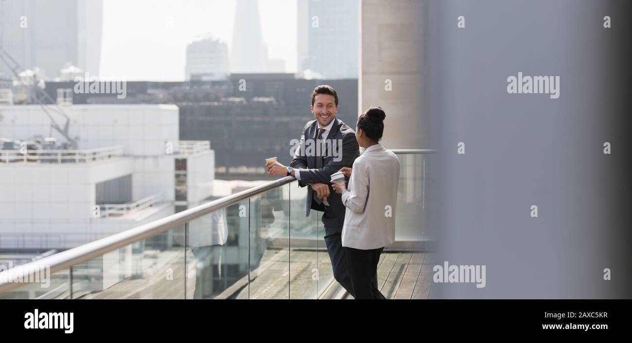 Business people talking on sunny, urban balcony Stock Photo