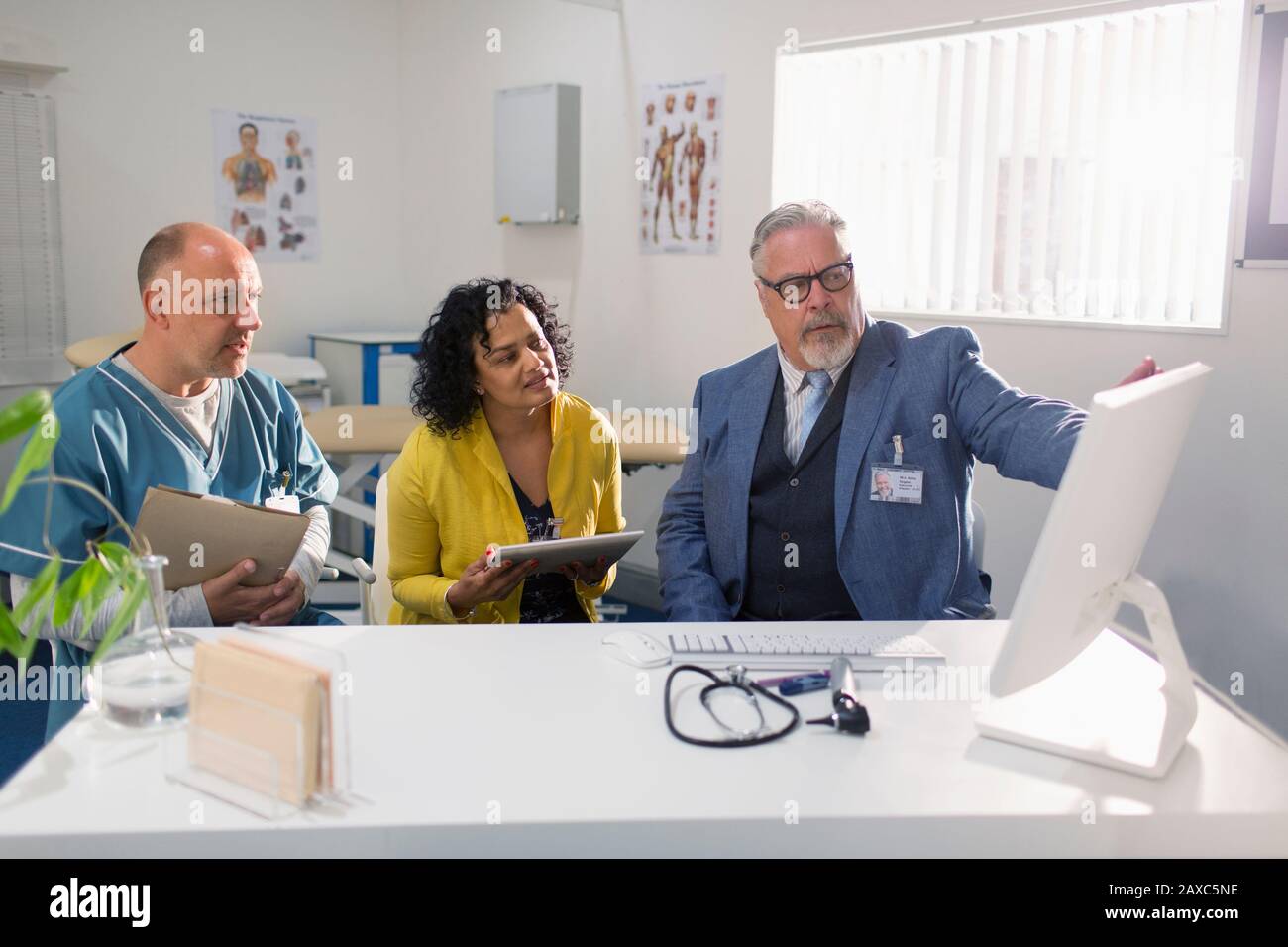 Doctors and administrator meeting at computer in doctors office Stock Photo