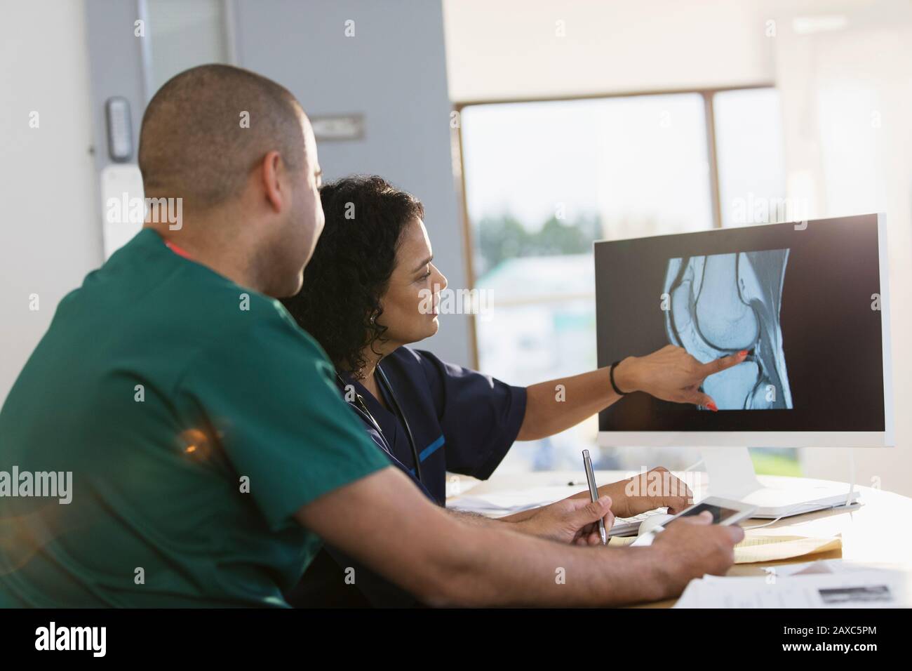 Nurses discussing digital x-ray at computer in clinic Stock Photo