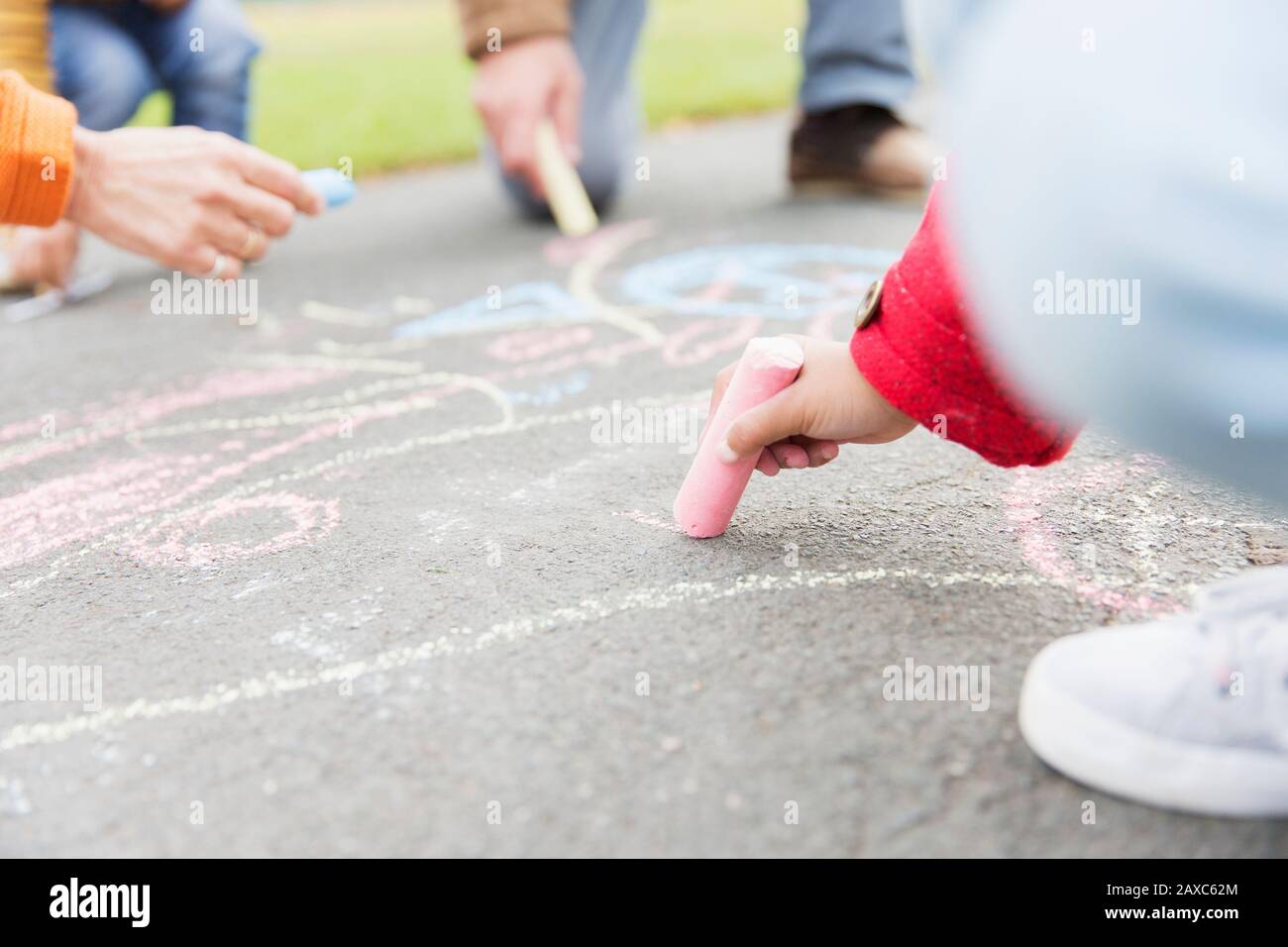 Girl drawing with sidewalk chalk Stock Photo - Alamy