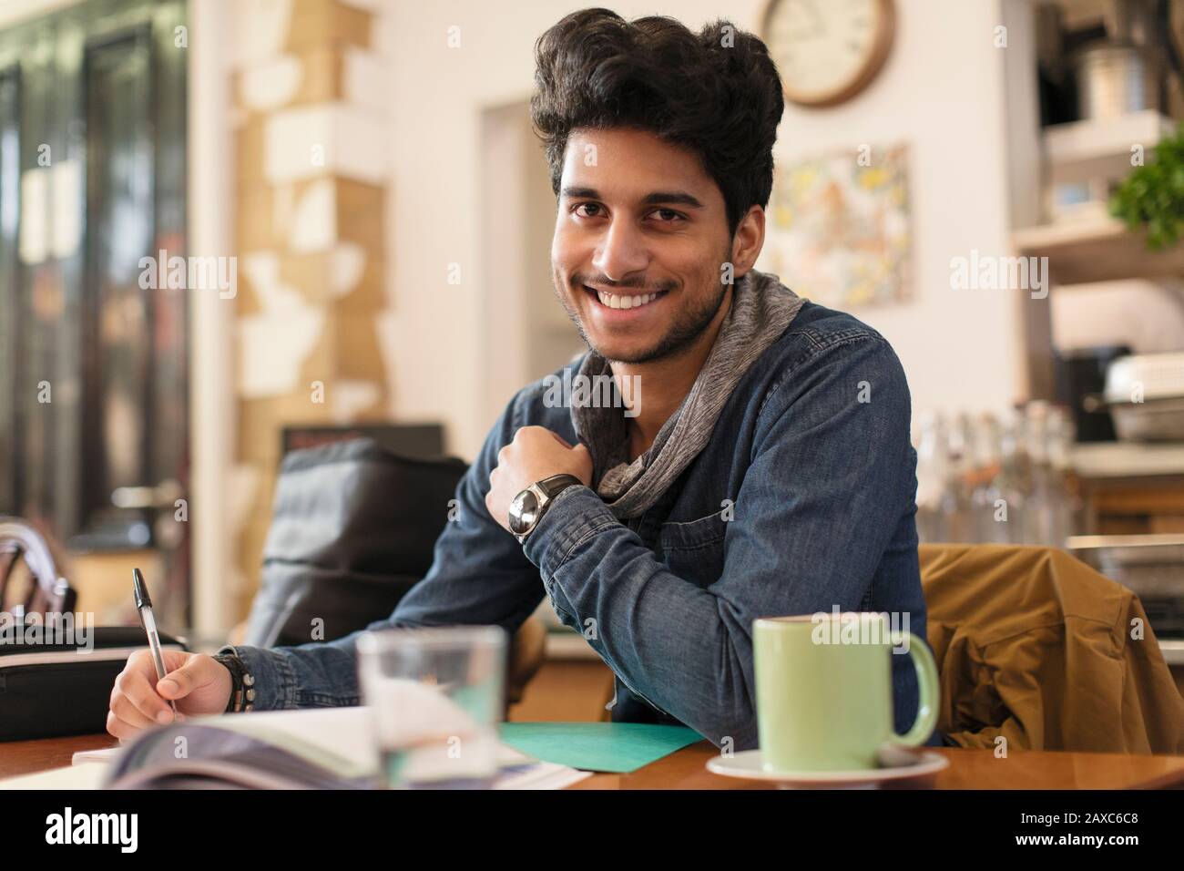 Portrait confident young male college student studying at cafe table Stock Photo