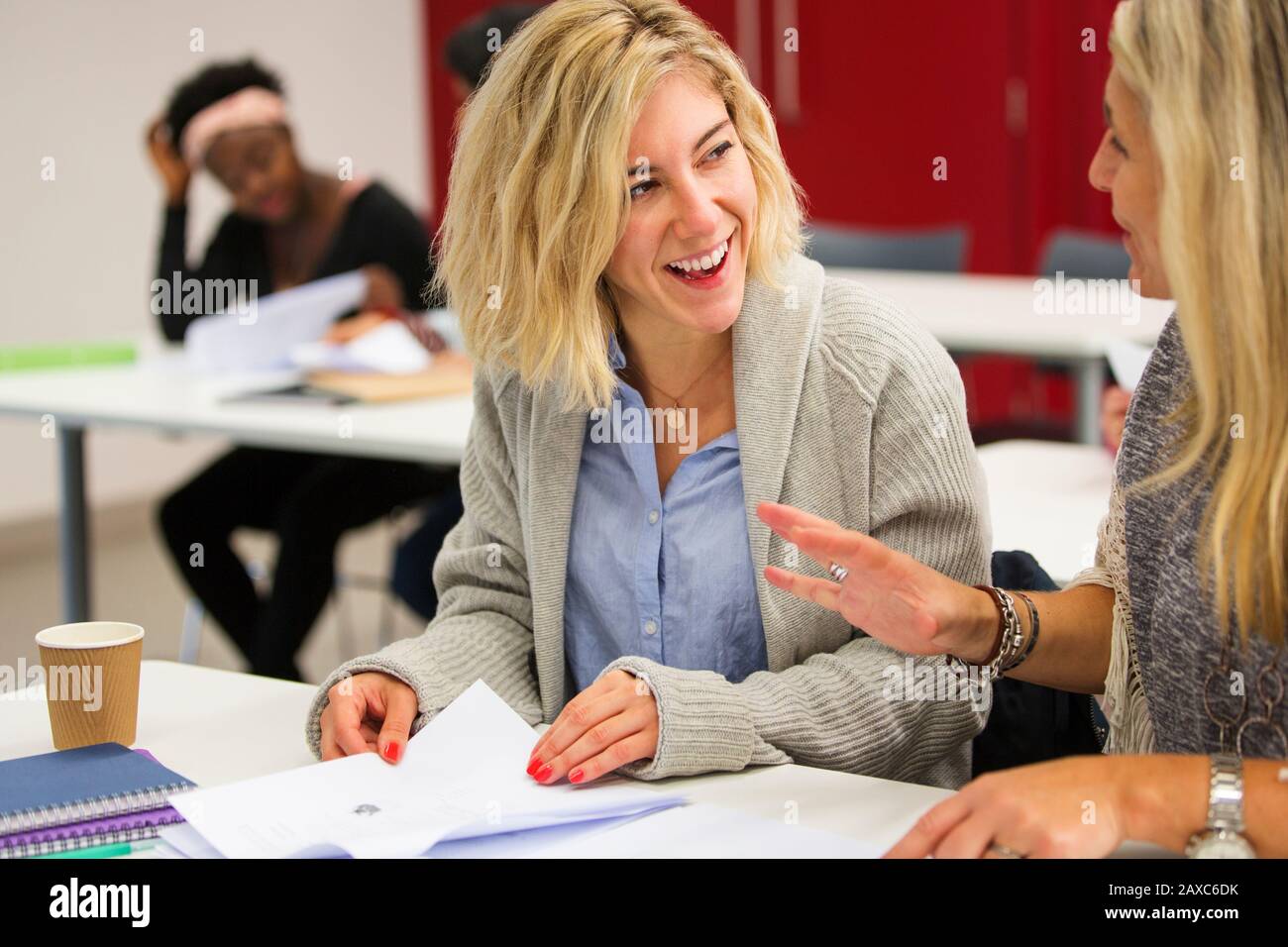 Female community college students talking, studying in classroom Stock Photo