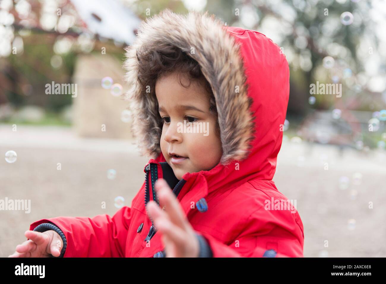 Cute, playful toddler boy playing with bubbles Stock Photo