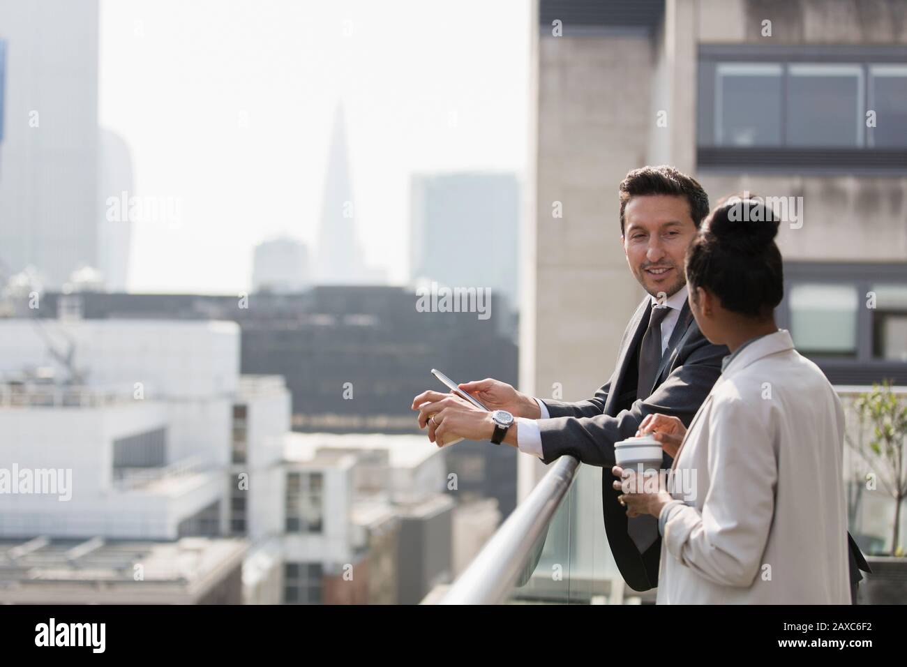 Business people talking on sunny, urban balcony Stock Photo