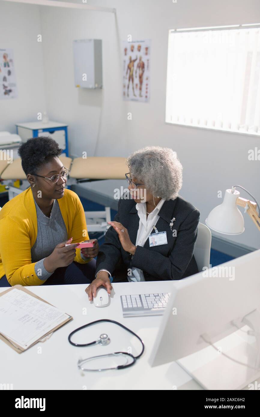 Female doctor prescribing medication to patient in doctors office Stock Photo