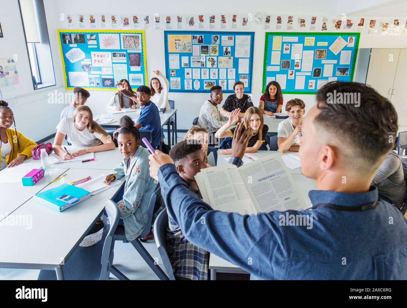 High school teacher calling on students during lesson in classroom Stock Photo