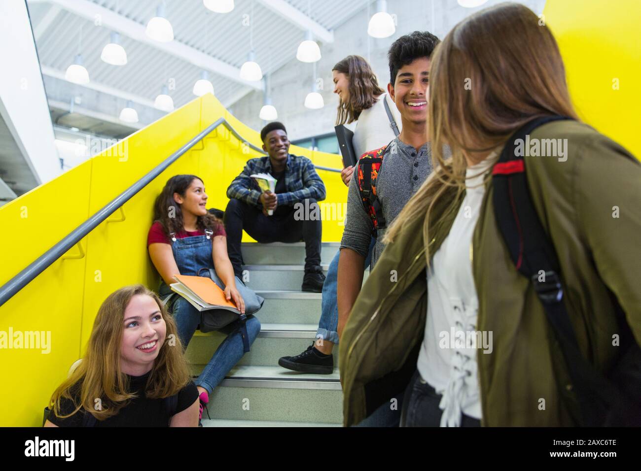 Junior high students hanging out, talking on stairs Stock Photo