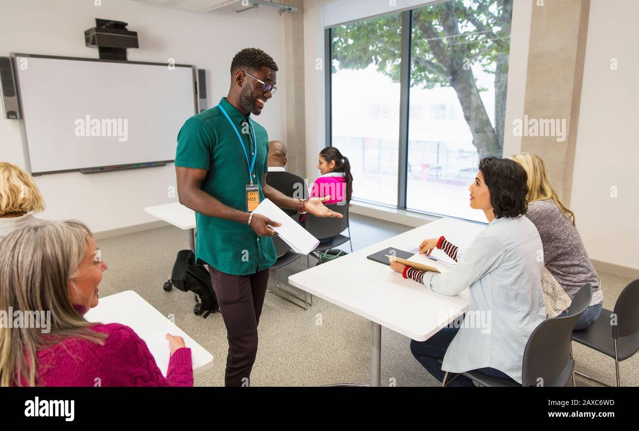 Community college instructor talking with students in classroom Stock Photo