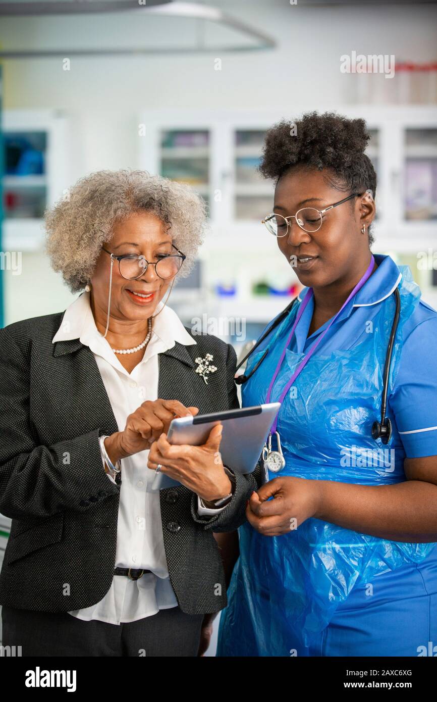 Female doctor and nurse using digital tablet in clinic Stock Photo