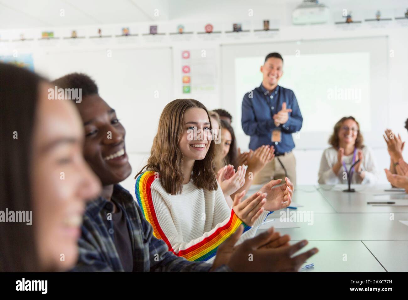 Happy high school students and teacher clapping in debate class Stock Photo
