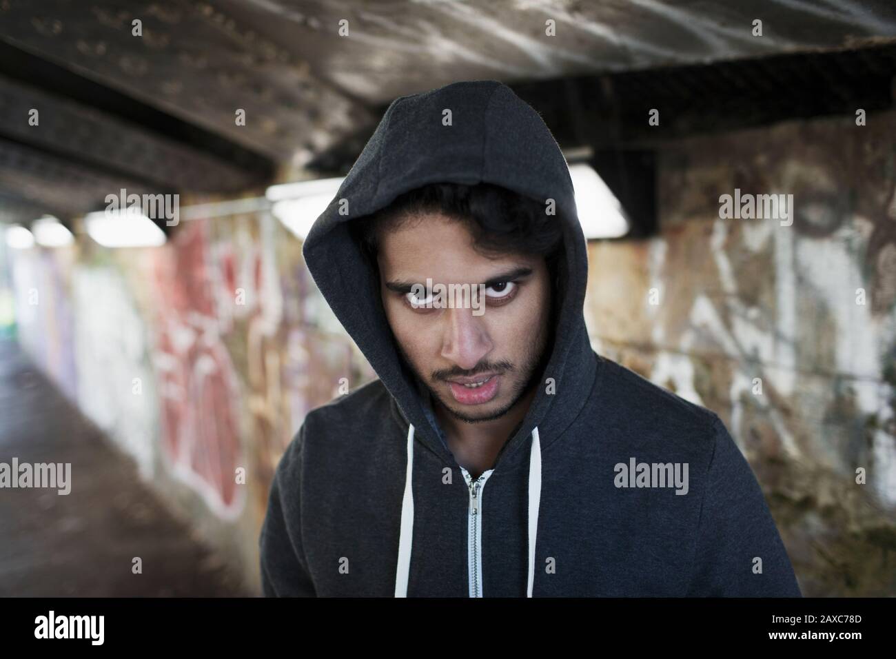 Portrait menacing young man in urban tunnel Stock Photo