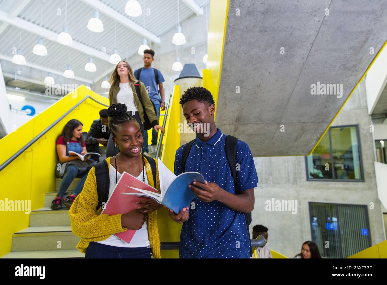 Junior high students studying at stairs Stock Photo