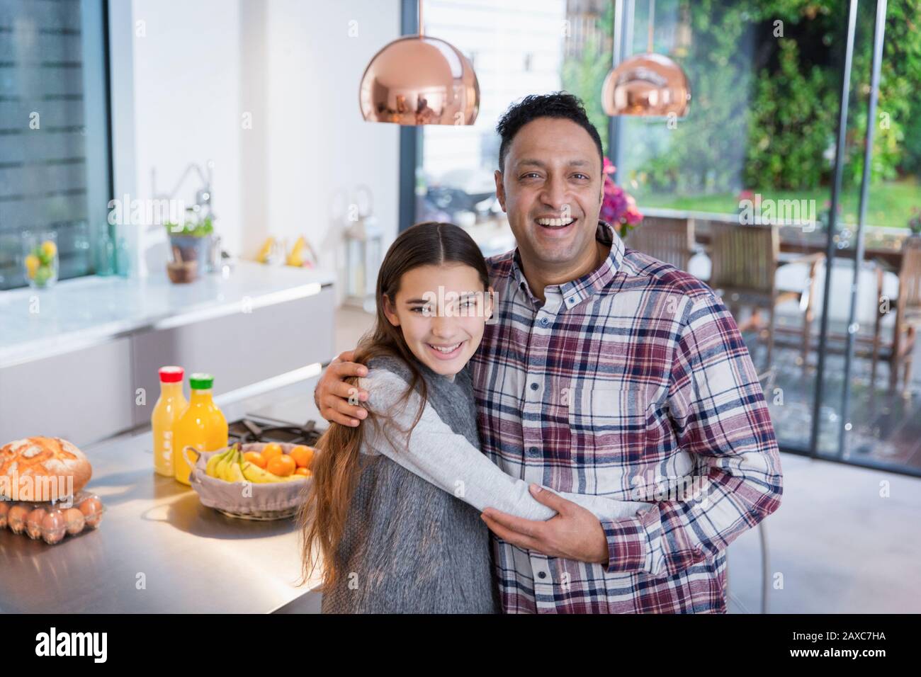 Portrait happy father and daughter hugging in kitchen Stock Photo