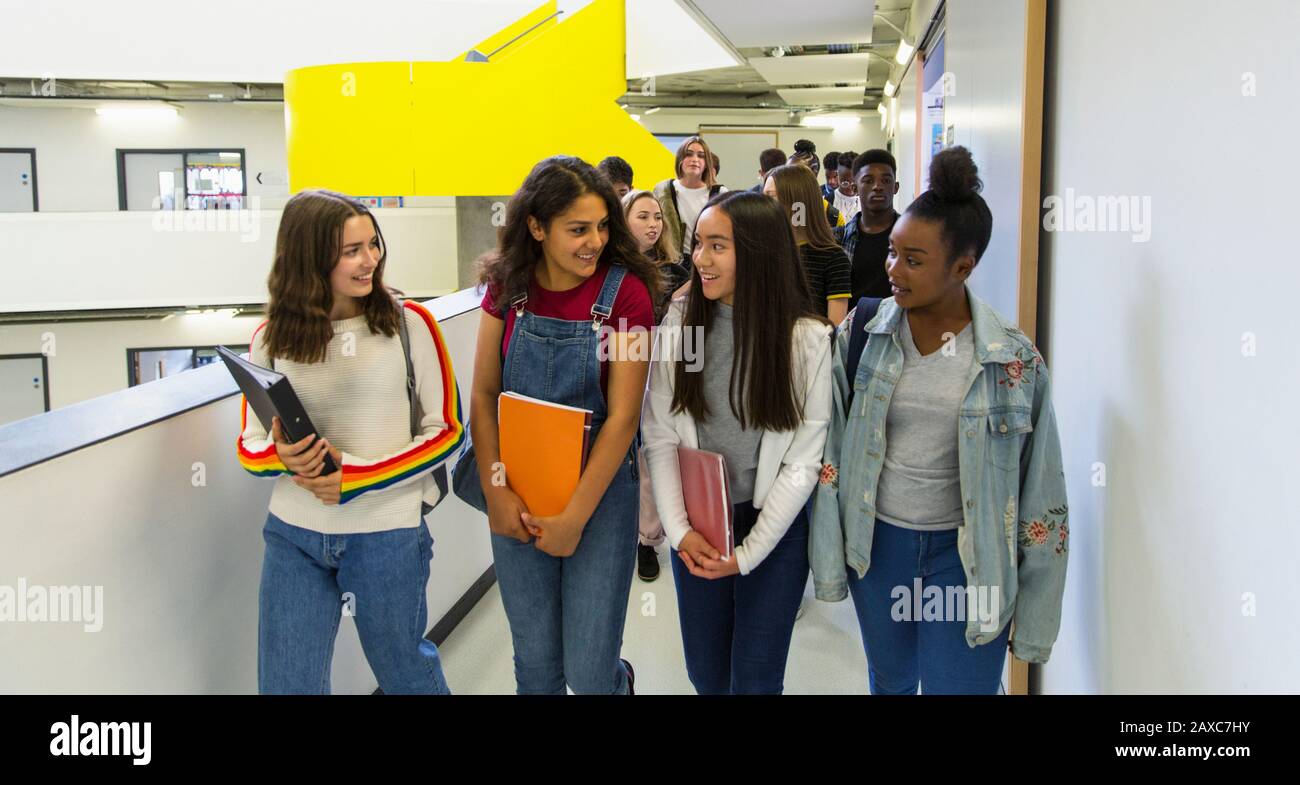 Junior high girl students walking in corridor Stock Photo